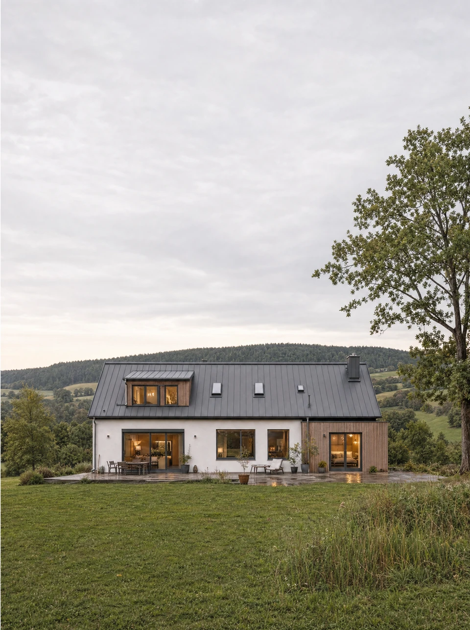 Haus mit Terrasse und Garten in einer hügeligen Landschaft; KI-generierte Illustration.